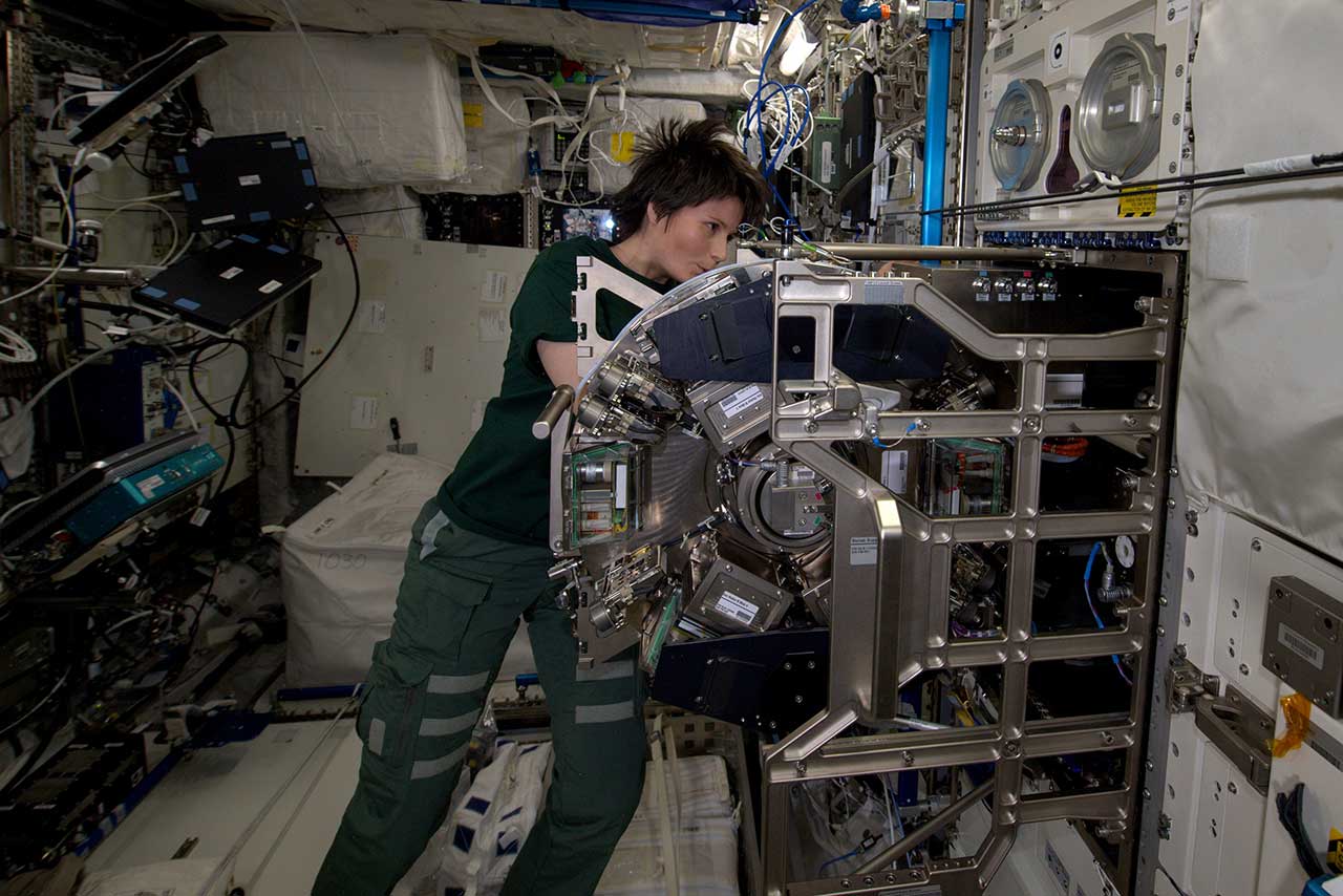 A photo of ESA astronaut Samantha Cristoforetti working in the International Space Station's Biolab facility.